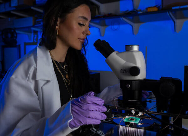 Woman looking into microscope in the Kickr Labs hardware accelerator
