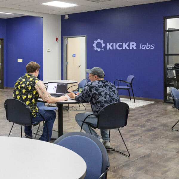 Two men sitting at a table in Kickr Labs hardware accelerator working on project